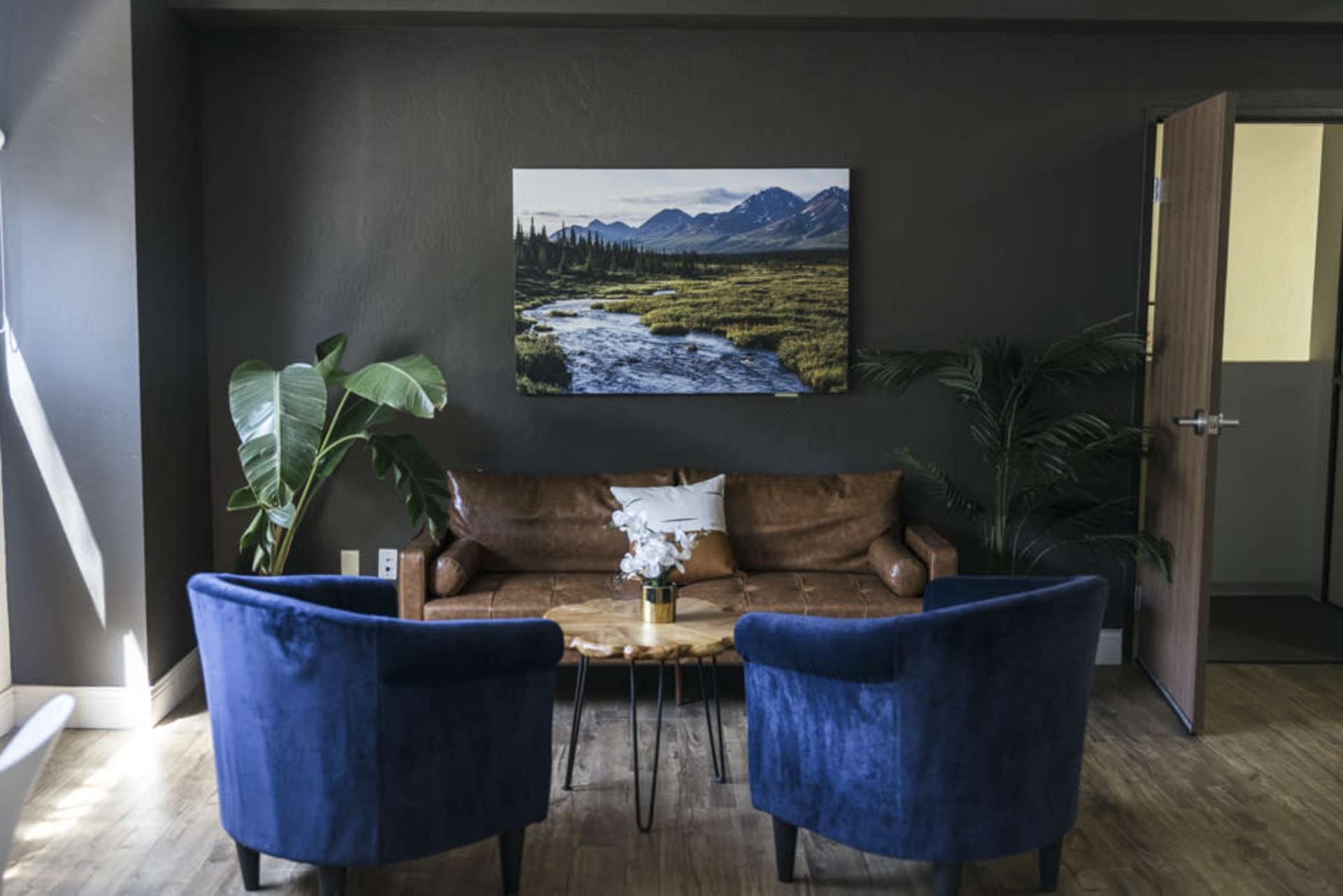 Seating corner with leather sofa and blue chairs
