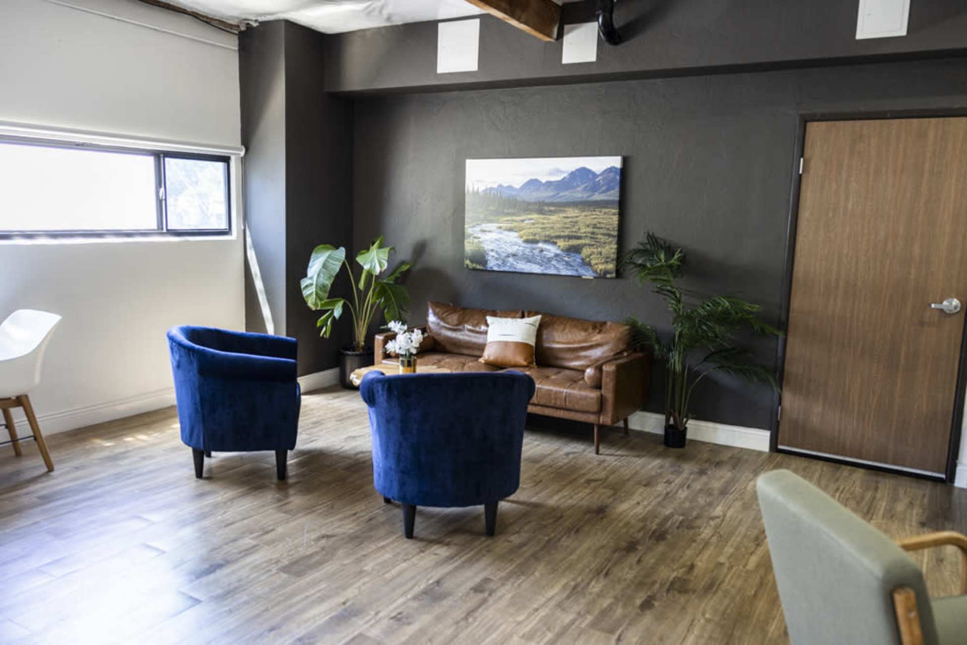 Sitting area with blue armchairs and leather sofa
