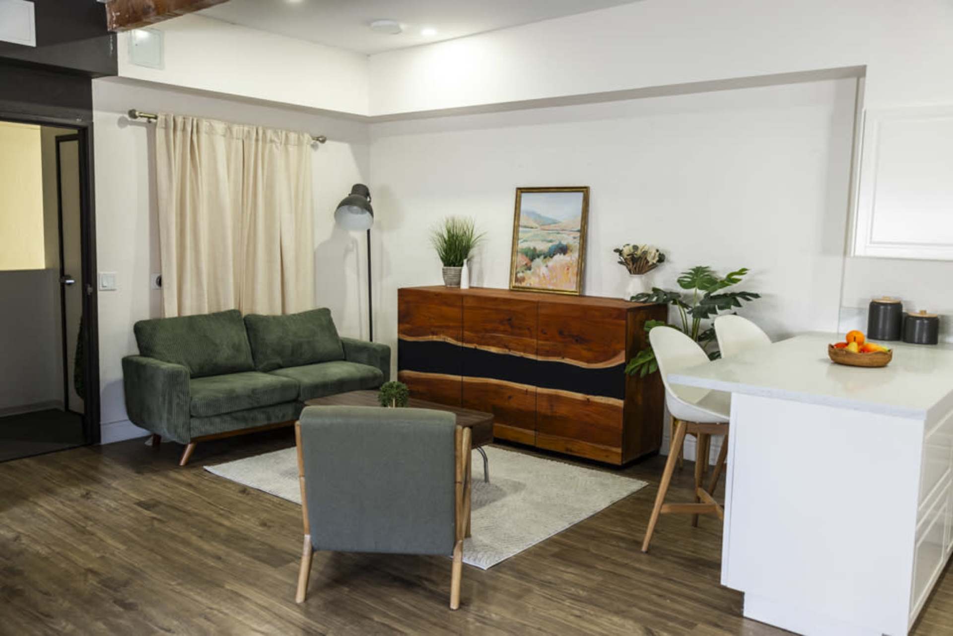 Living room with green sofa and light wood floor